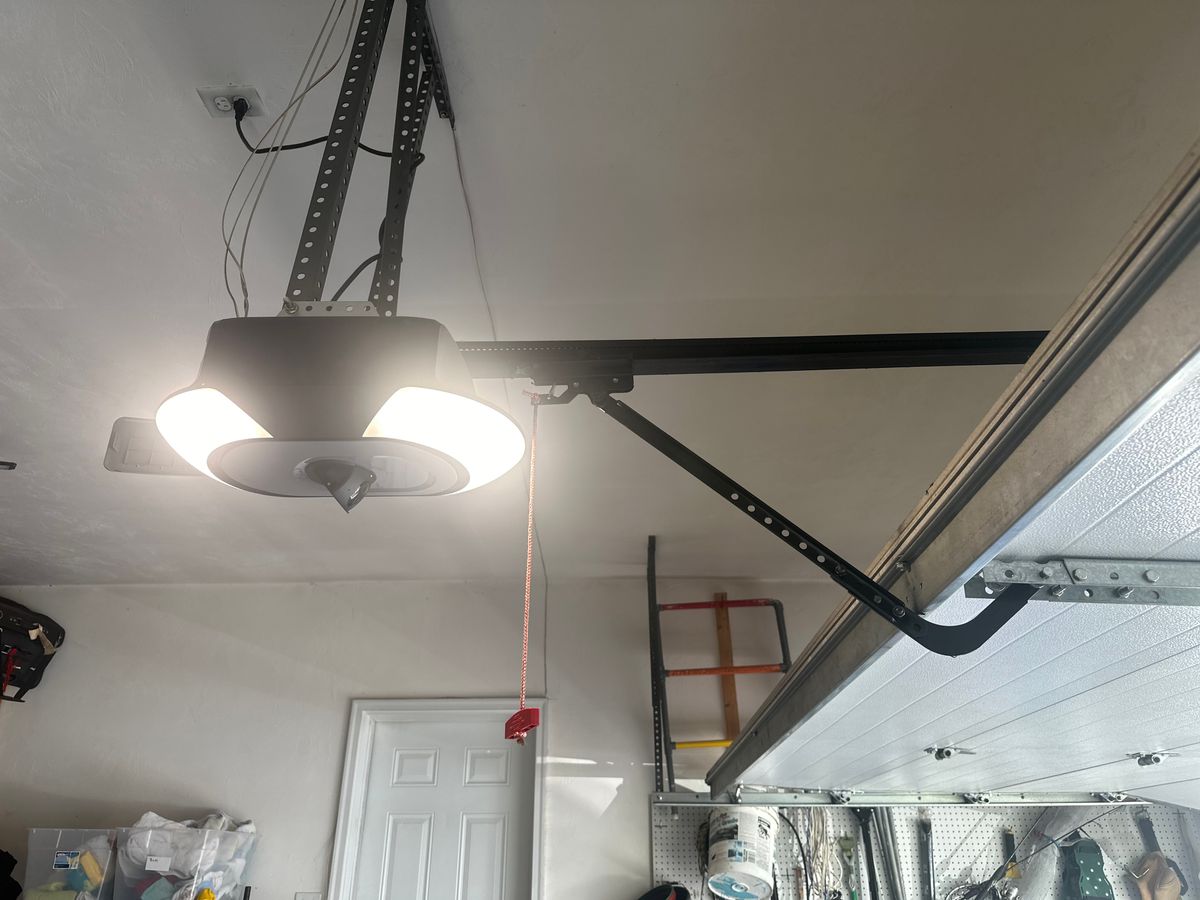 Modern residential garage door opener with LED light installed on ceiling